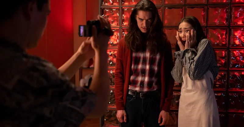 Actors portray a tense scene indoors with dramatic lighting and expressions.