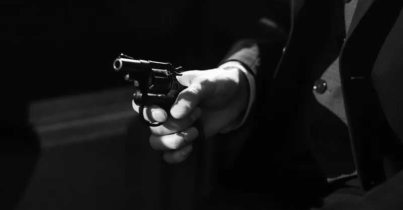Black and white image capturing a suspenseful noir scene with a handgun.