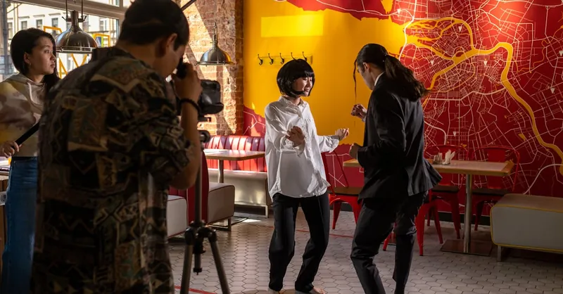 Filmmaking scene in a lively café, capturing actors and crew in creative action.