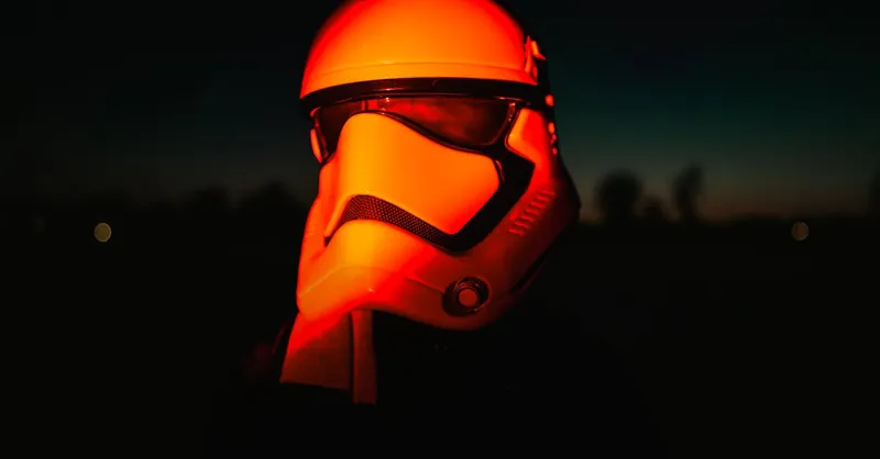Moody night shot of a sci-fi helmet illuminated by red light, evoking a cinematic feel.