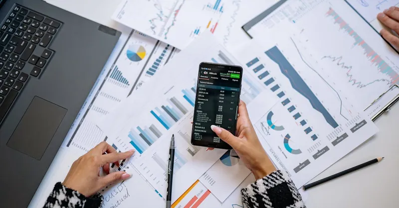A top view on charts and smartphone in an office, showcasing data analytics.