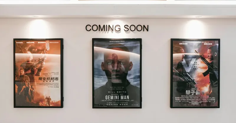 Framed posters of upcoming movies in a cinema hallway under