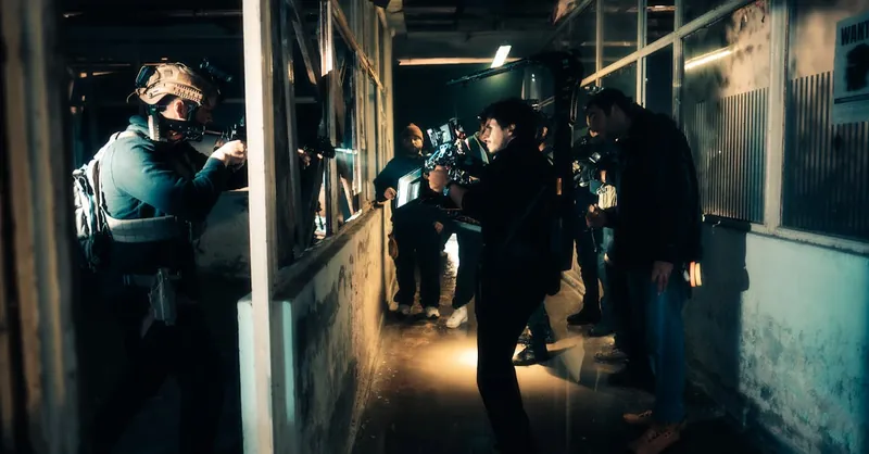A cinematic scene capturing actors filming an intense action sequence in a dimly lit warehouse.