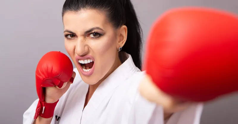 Fierce female karateka striking a powerful punch during a studio shoot.