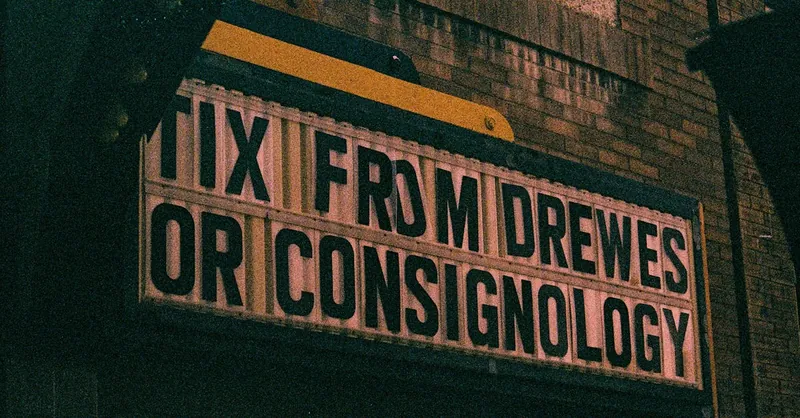 A vintage cinema marquee sign displaying text at night, offering a nostalgic urban vibe.