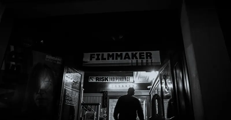 An individual enters a filmmaker-themed building at night, evoking a mysterious artistic vibe.